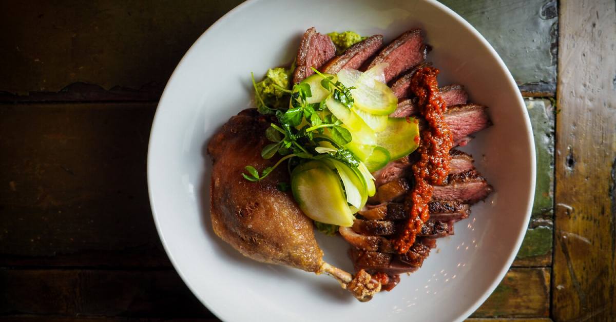 view of duck leg and sides on a plate