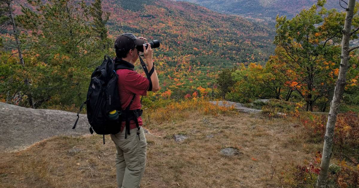 Man taking a photo during a hiking trip