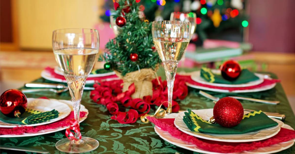 dinner table with colorful Christmas decor, plates, and glasses