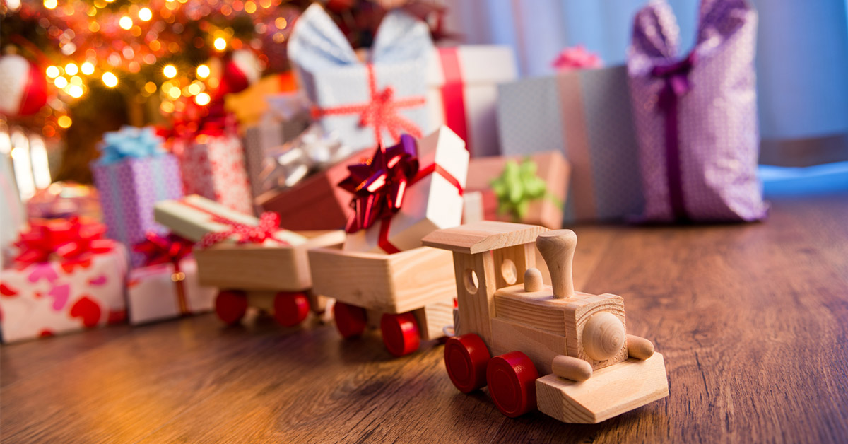 toy train with other gifts under a christmas tree