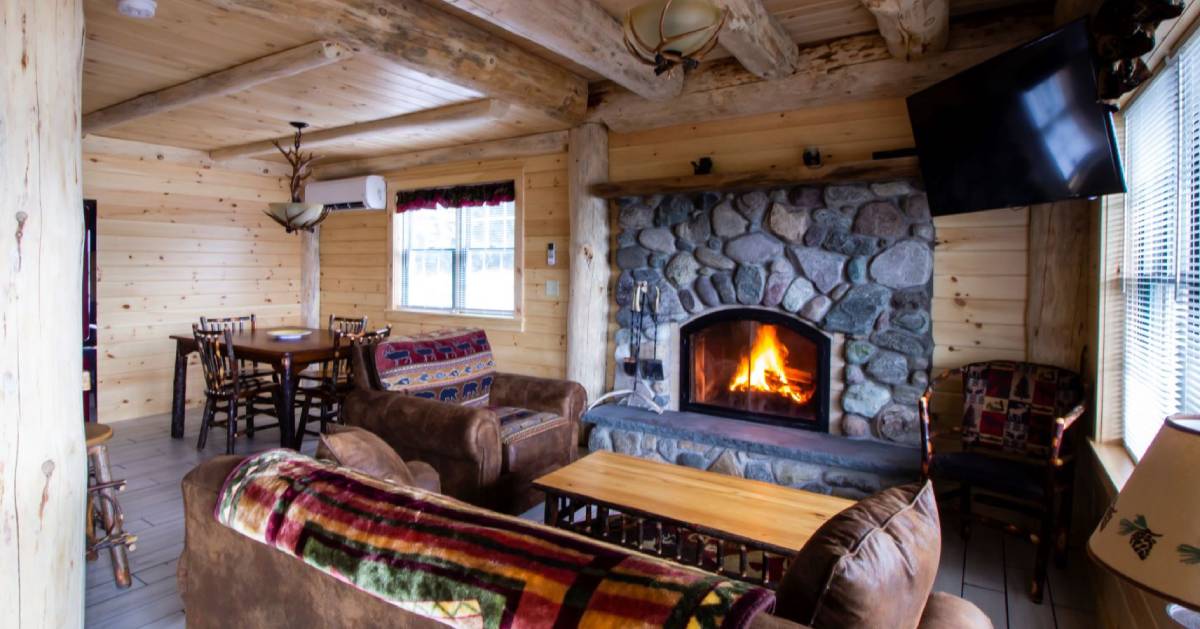 inside wooden cabin with a fire in the fireplace