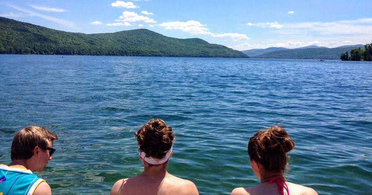 three people looking out at lake