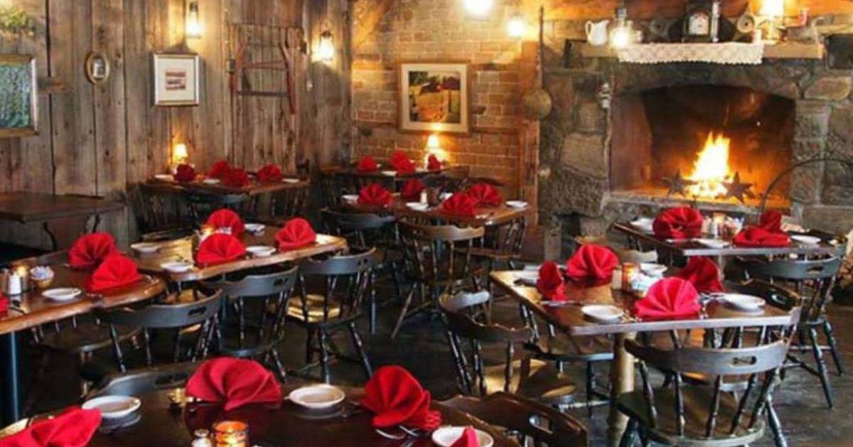 rustic dining room with tables and a fireplace