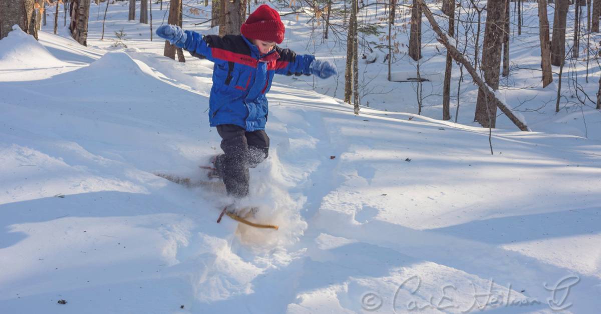 boy wearing snowshoes in the snow