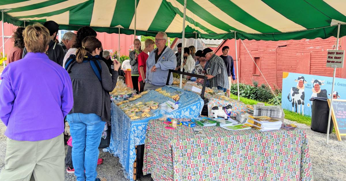 people under a tent doing food and cheese tasting