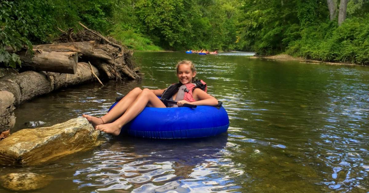 girl floating down a river in an inner tube