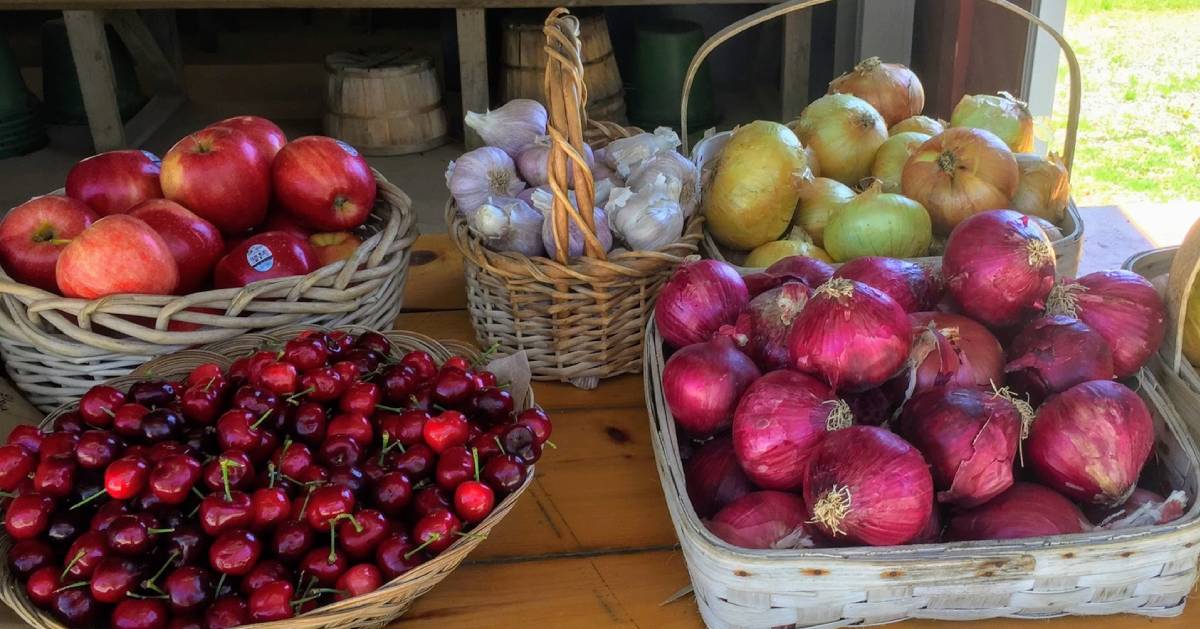 cherries, apples, garlic, and onions on a table