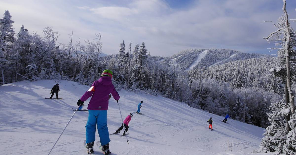 a group of people skiing down a mountain in winter