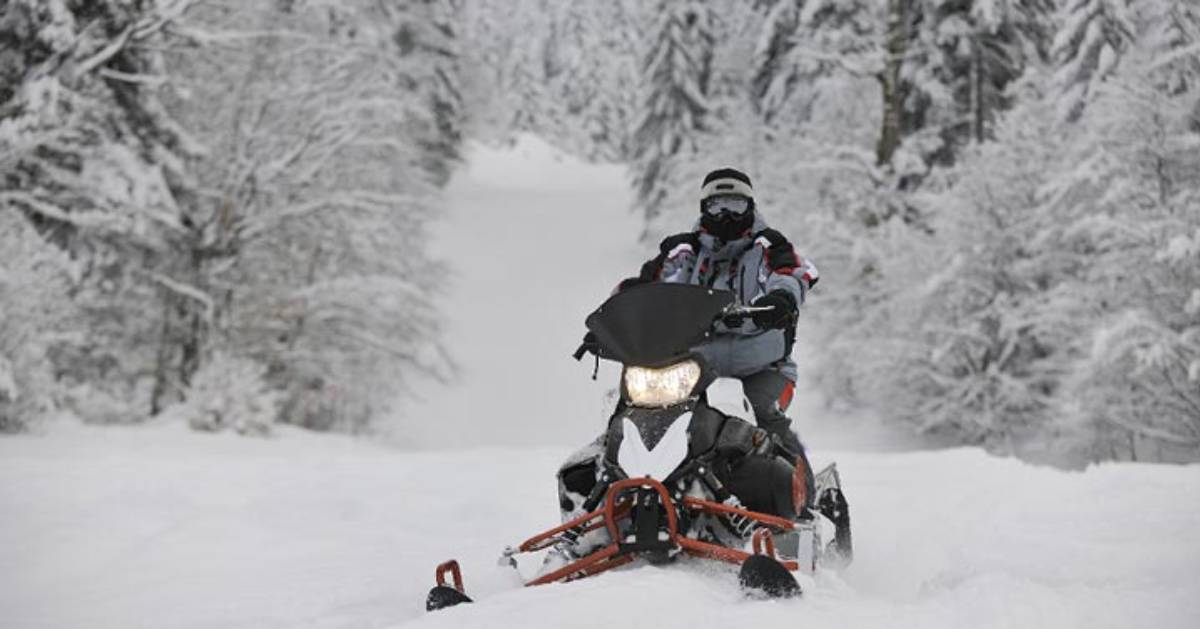 snowmobiler riding through snow
