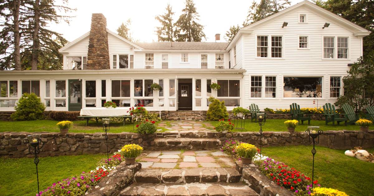 a white bed and breakfast with stone steps leading to the entrance