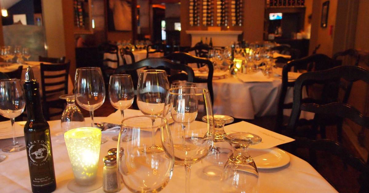 wine glasses and olive oil and candle on a table in a restaurant