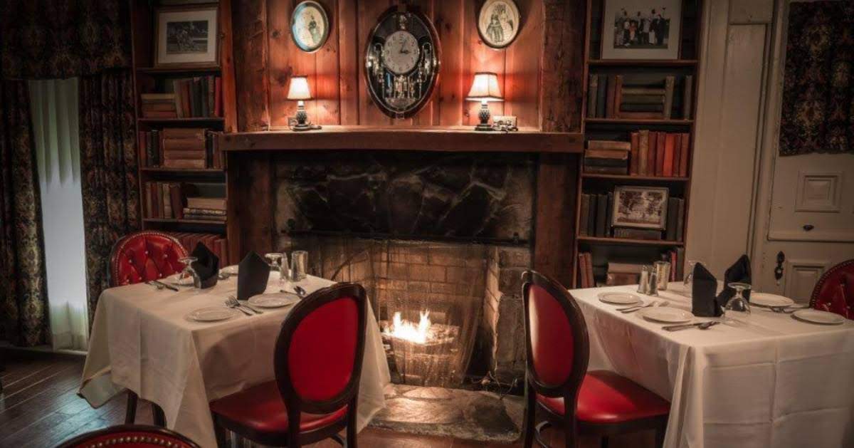 two tables near a fireplace in a restaurant dining room