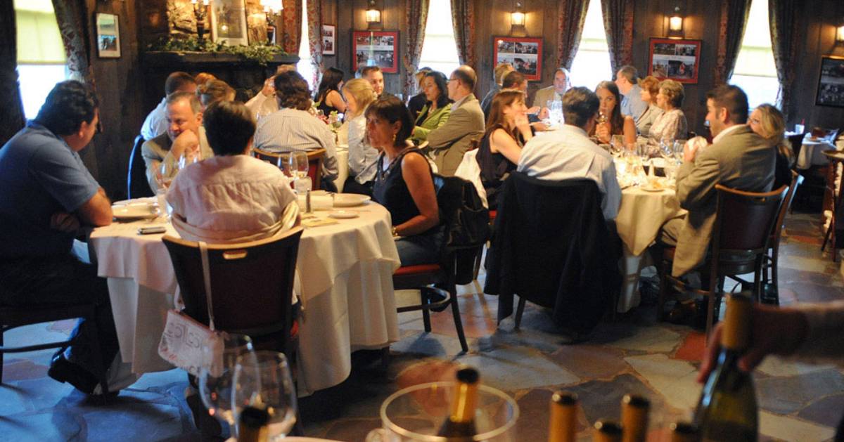 people seated at round tables in a restaurant dining room