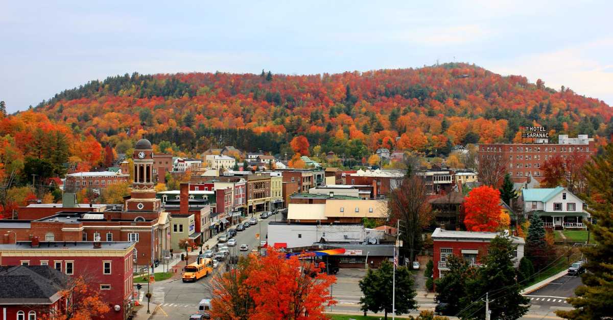 saranac lake in the fall, vibrant leaves and mountains in the distance