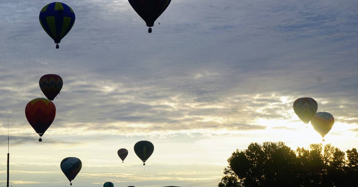 hot air balloons rising at sunrise