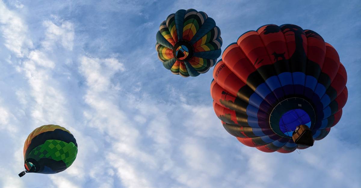 view looking up at three hot air balloons