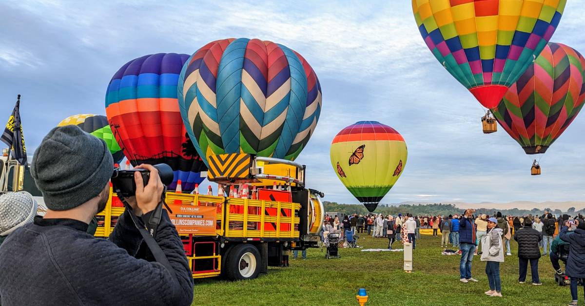 man takes photos with camera at balloon festival