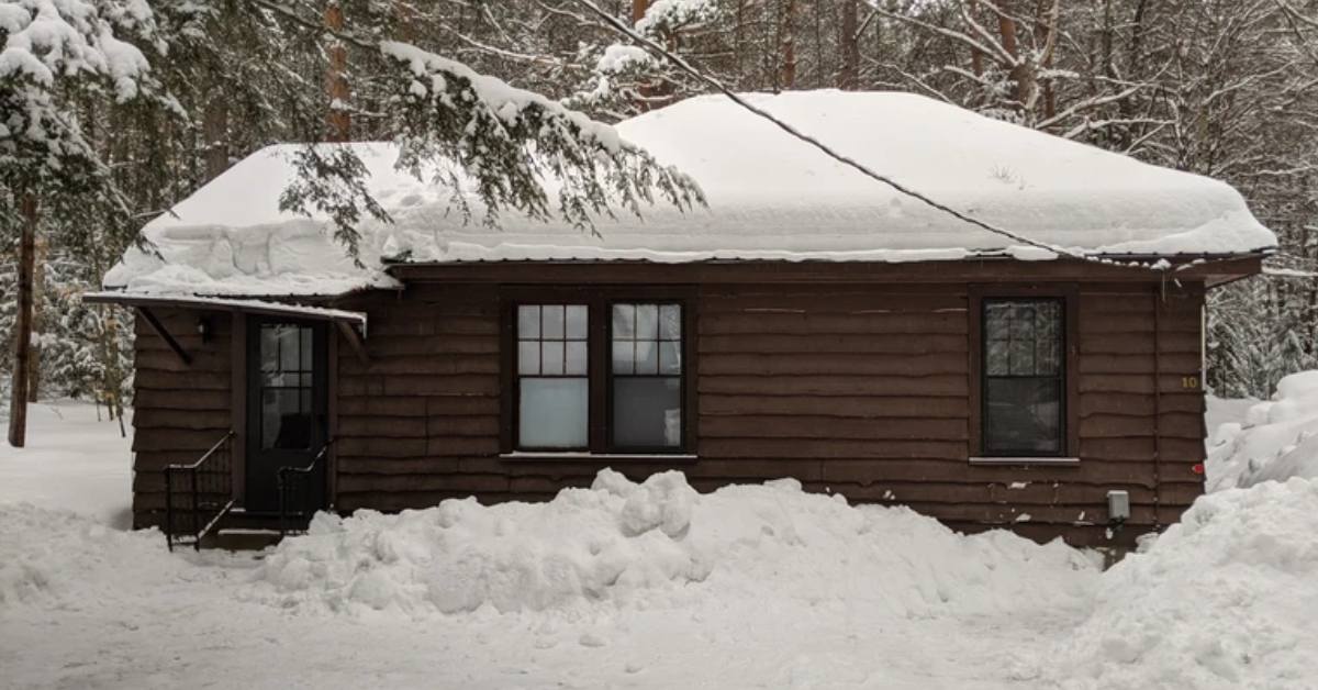 exterior of a brown cabin with snow all around it