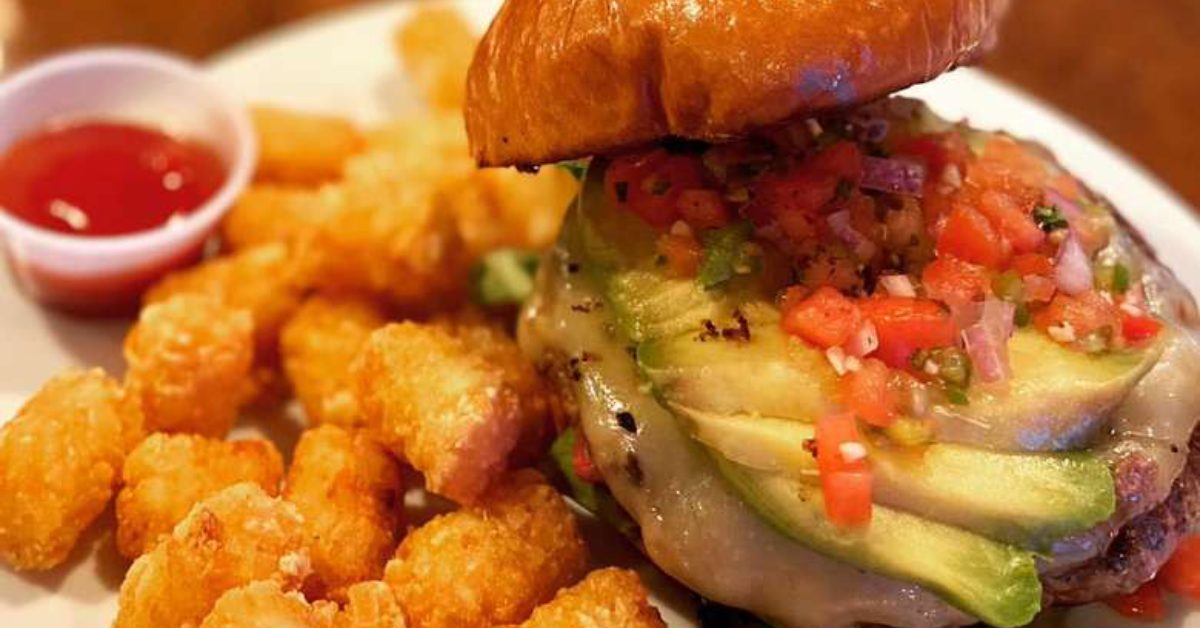 a burger with tater tots and ketchup