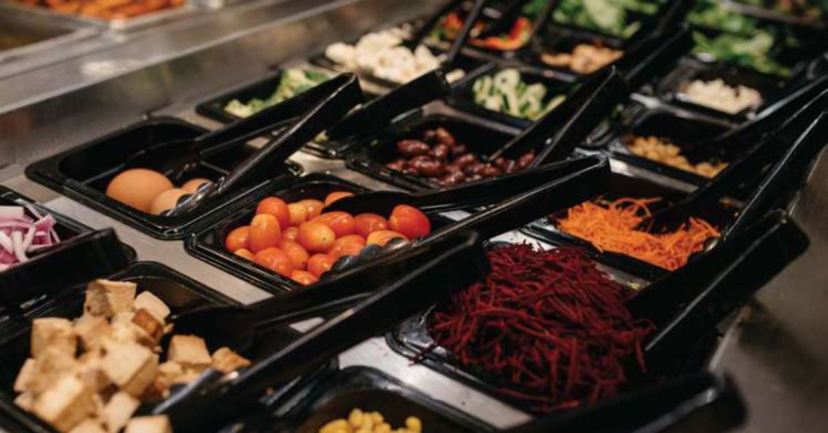 a salad bar with tons of veggies and tofu