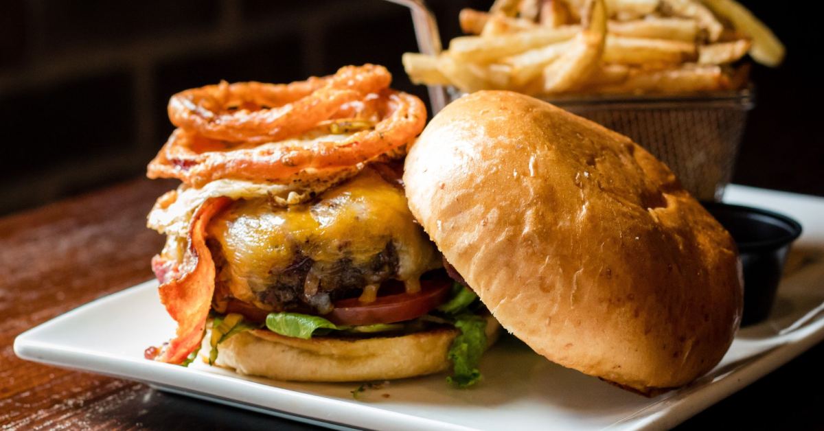 a burger with fries in the background