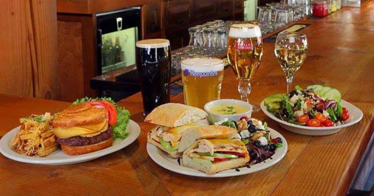 plates of food and beer glasses on a bar