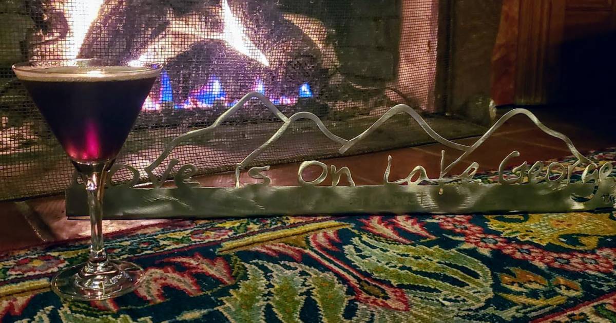 martini next to a fire with a love is on lake george sign