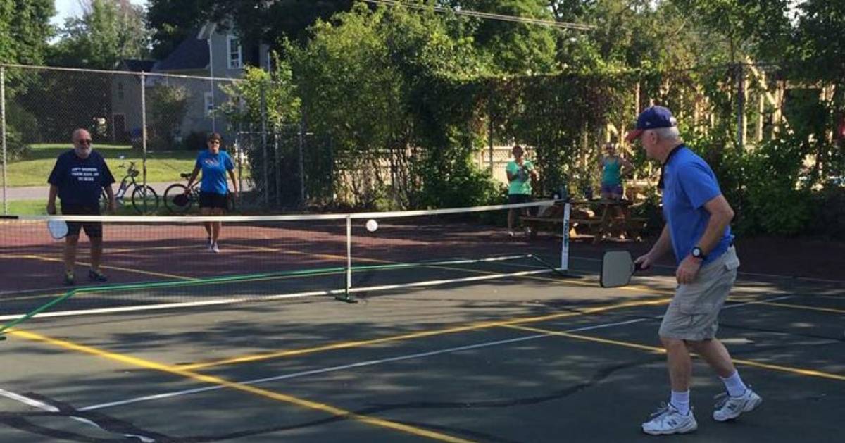 group of four playing pickleball on an outdoor court