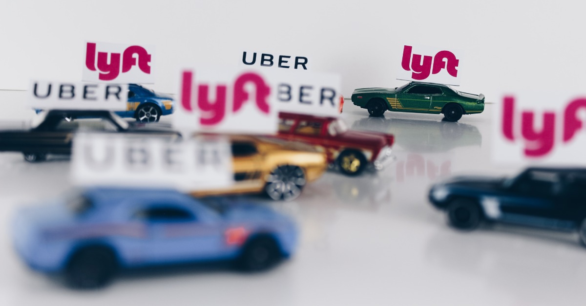 toy cars with uber and lyft signs on top against a white background