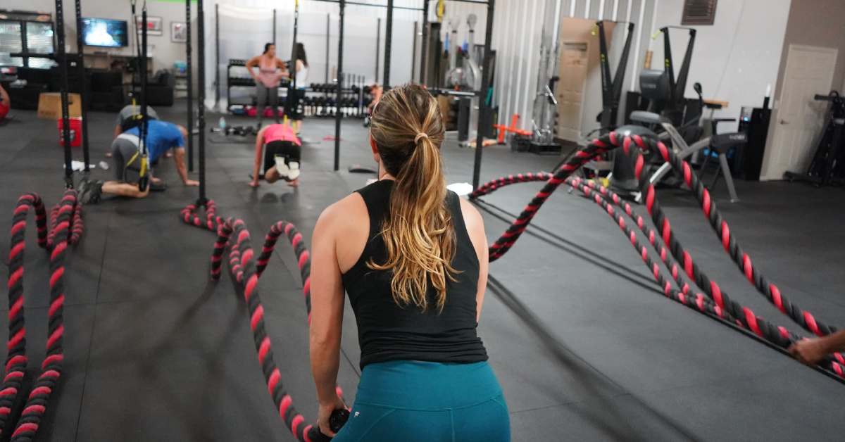 woman at fitness studio using ropes workout