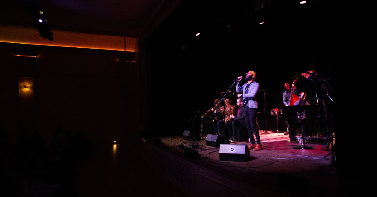 group performing a concert on stage with light shining down