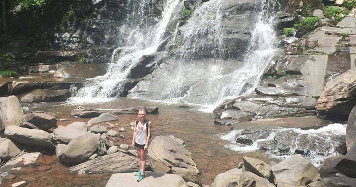 woman standing near base of waterfall