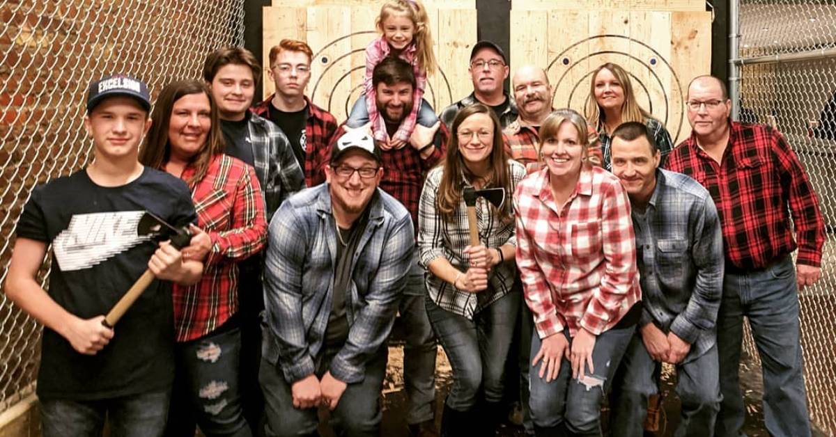 group of people standing in front of axe throwing area