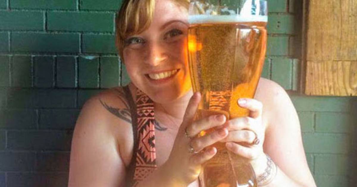 woman holding large glass of beer