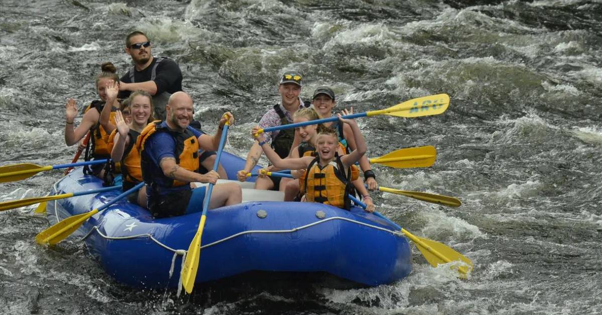 people whitewater rafting in a blue raft