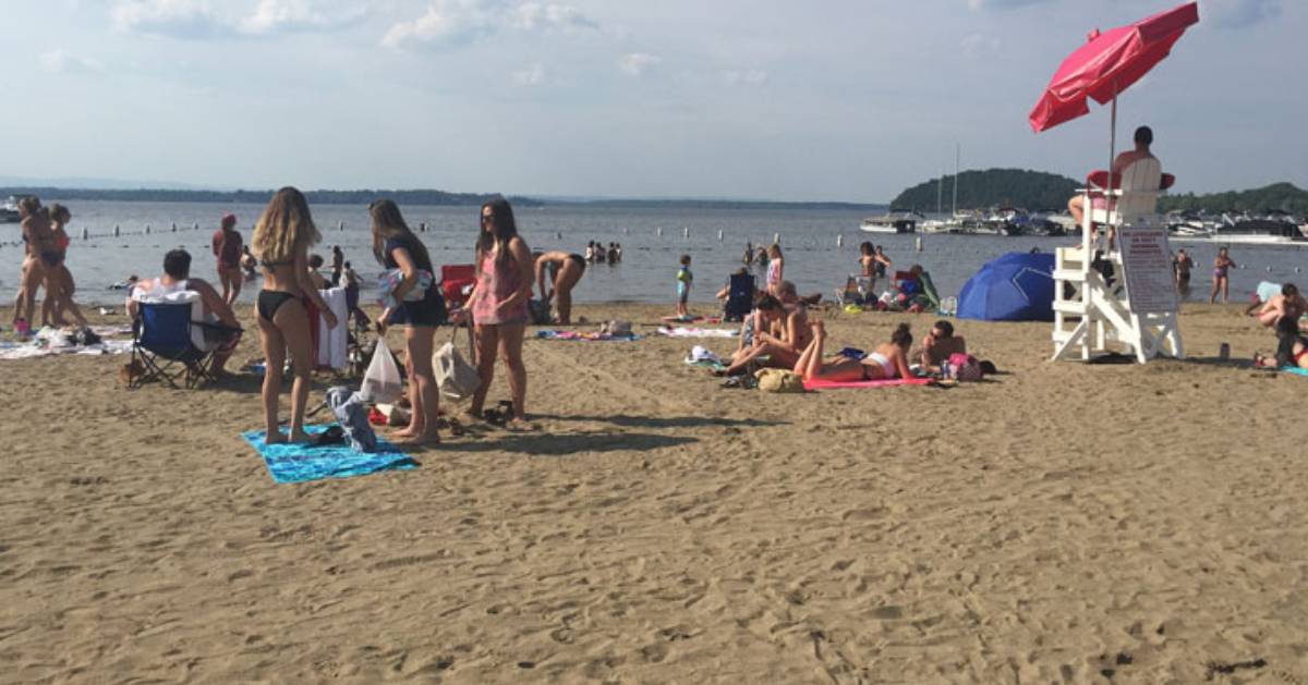 people at a beach on a lake