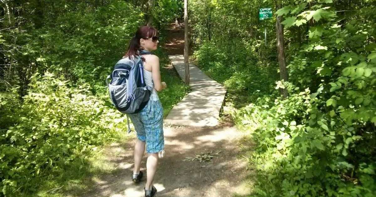 woman with back[ack on trail