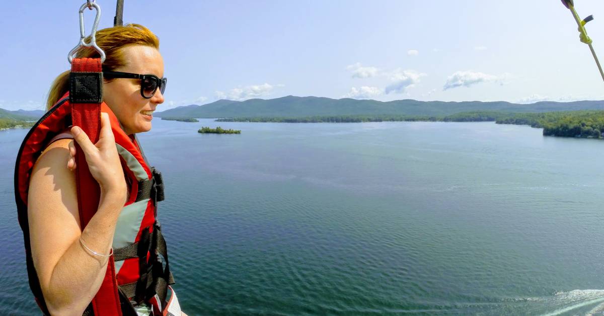 woman parasails over lake