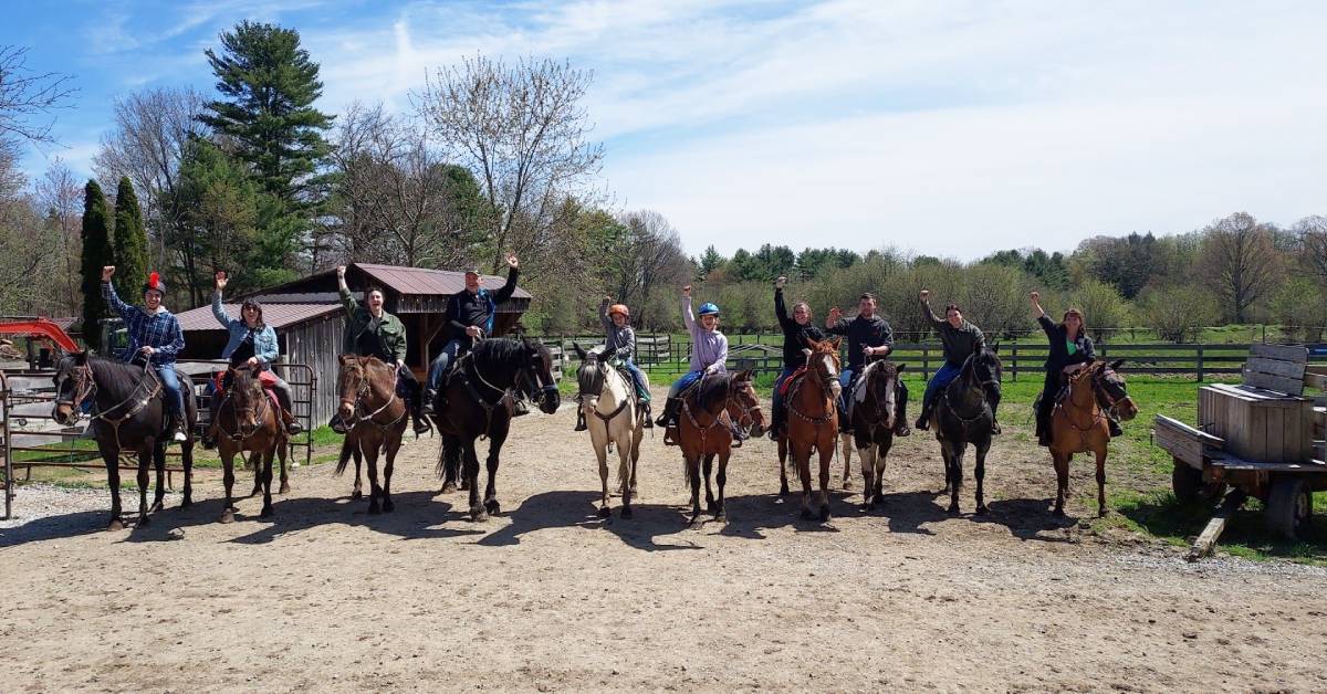 group of horseback riders on a farm