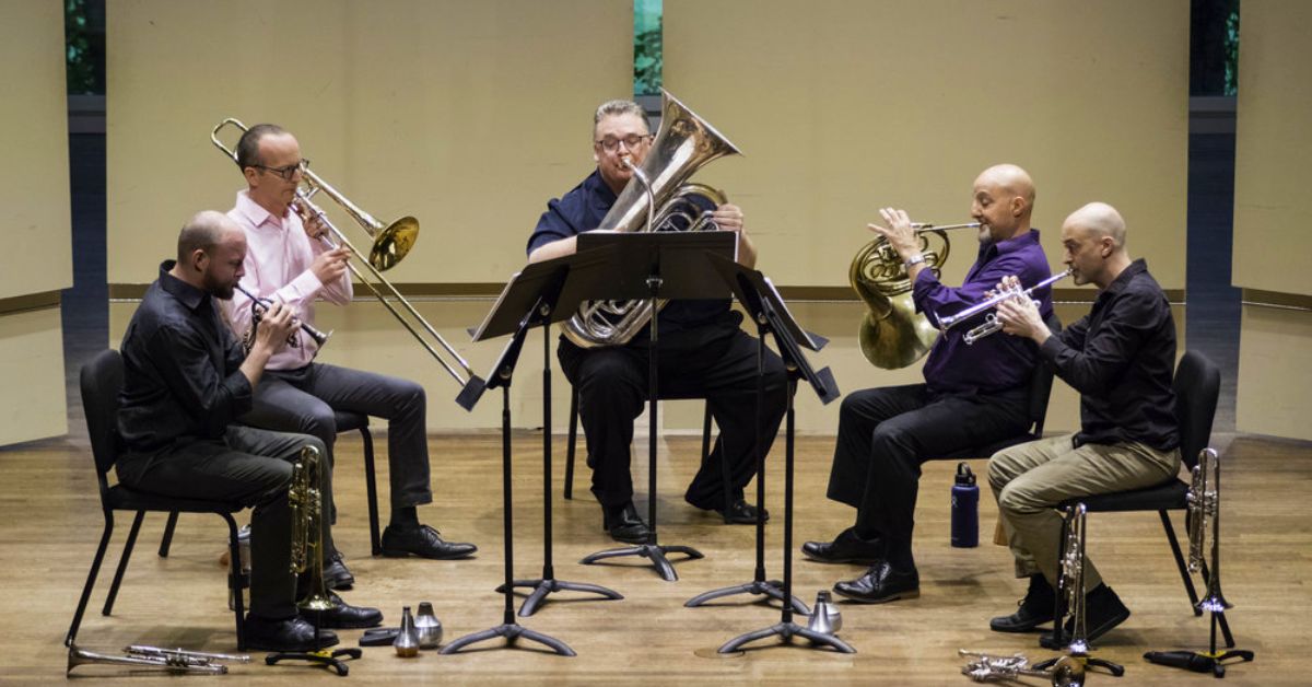 five brass musicians on stage