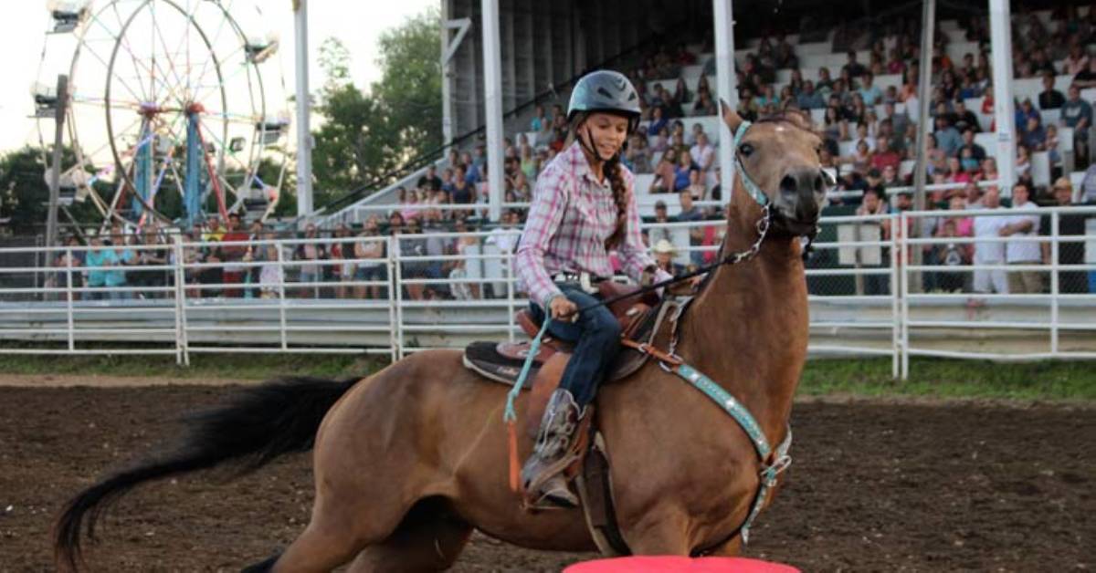 girl riding on a horse in an arena