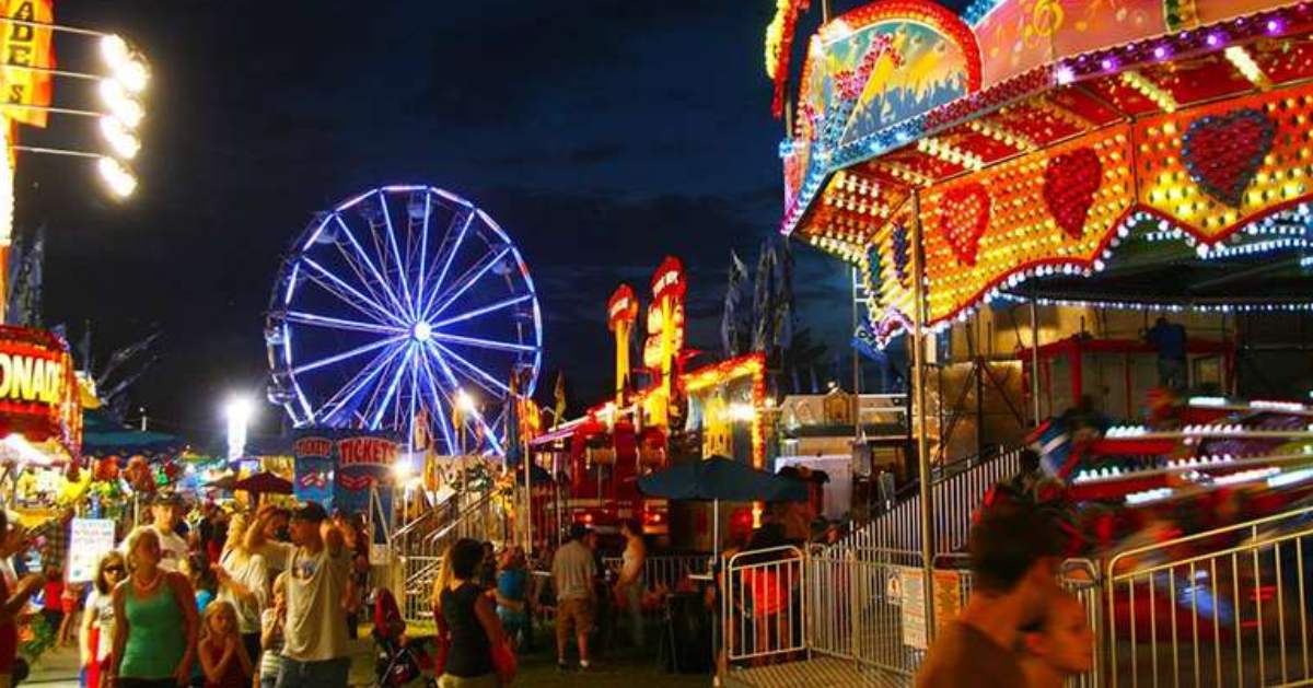 people walking around a fair at night