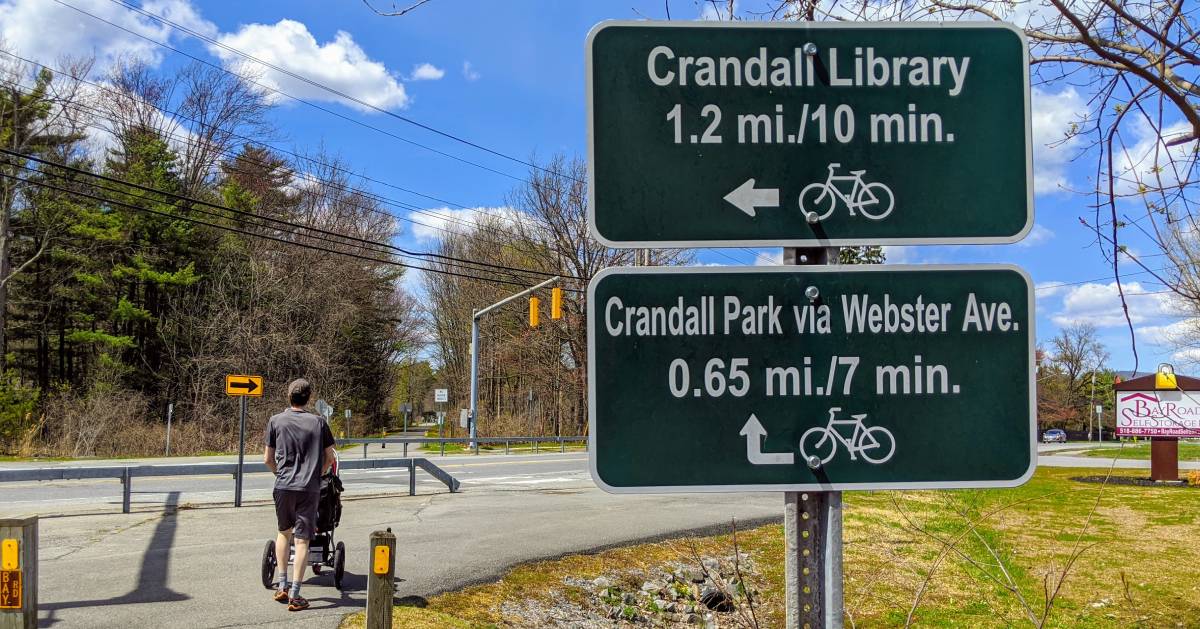 dad pushes stroller near road