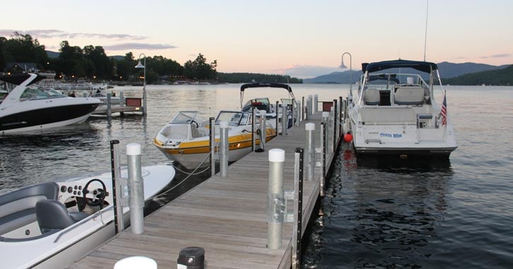 many boats near a dock on a lake