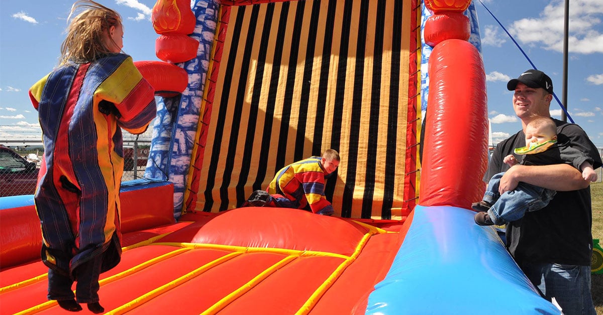 kids jumping on an inflatable velcro wall