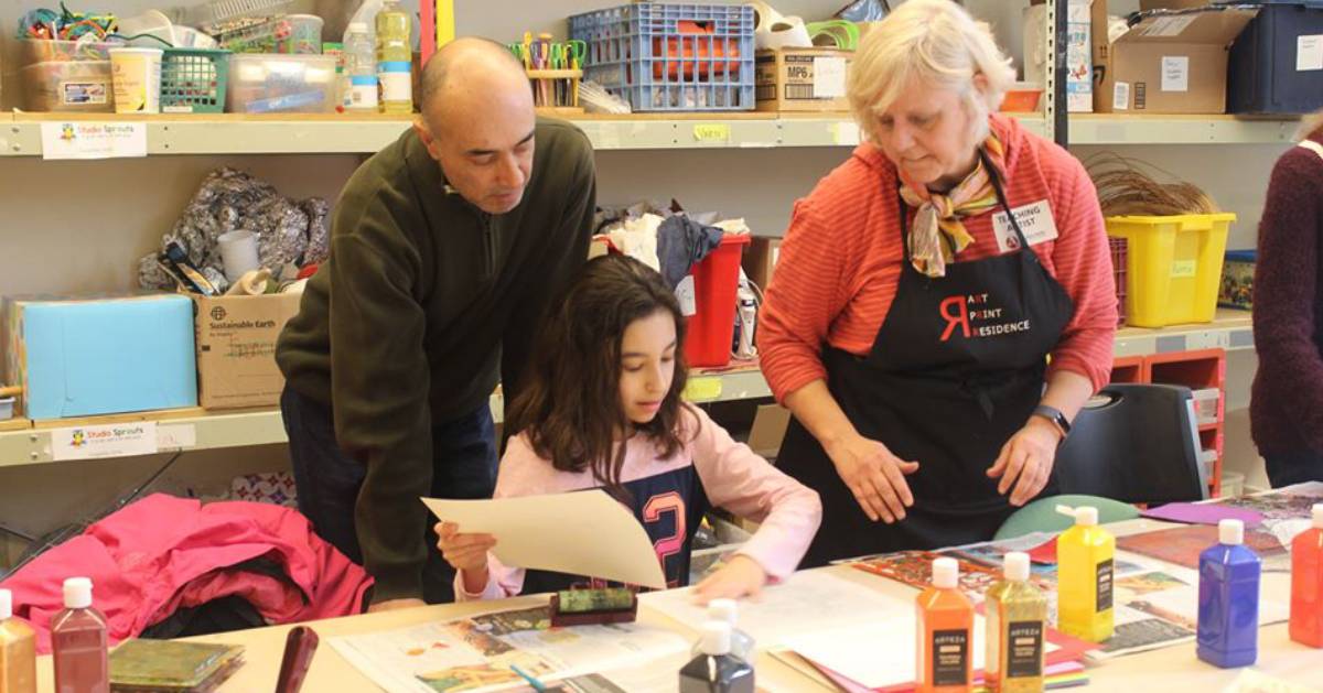 man, woman, and girl at arts and crafts table