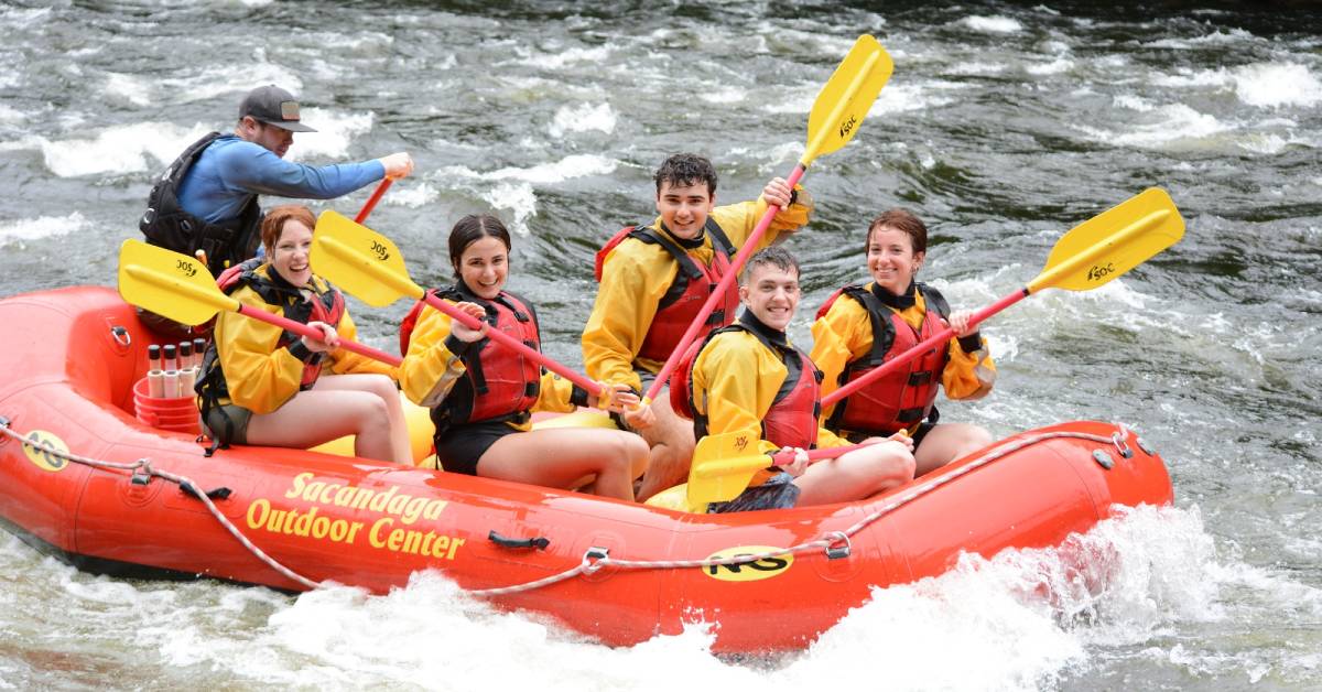 several smiling people in a raft