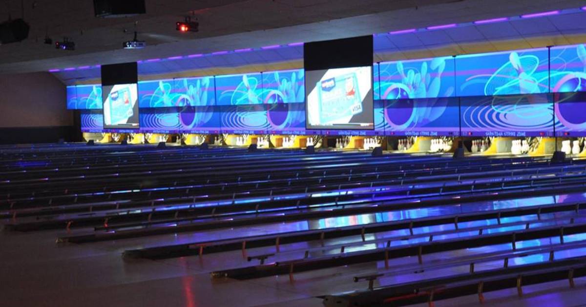 bowling alley with colorful lights above lanes