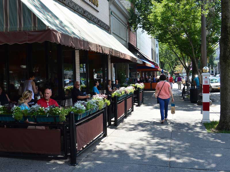Patio diners and people walking on Broadway in Saratoga Springs