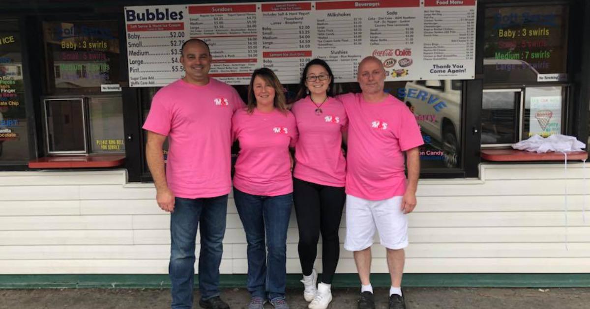 four people in pink shirts in front of ice cream window